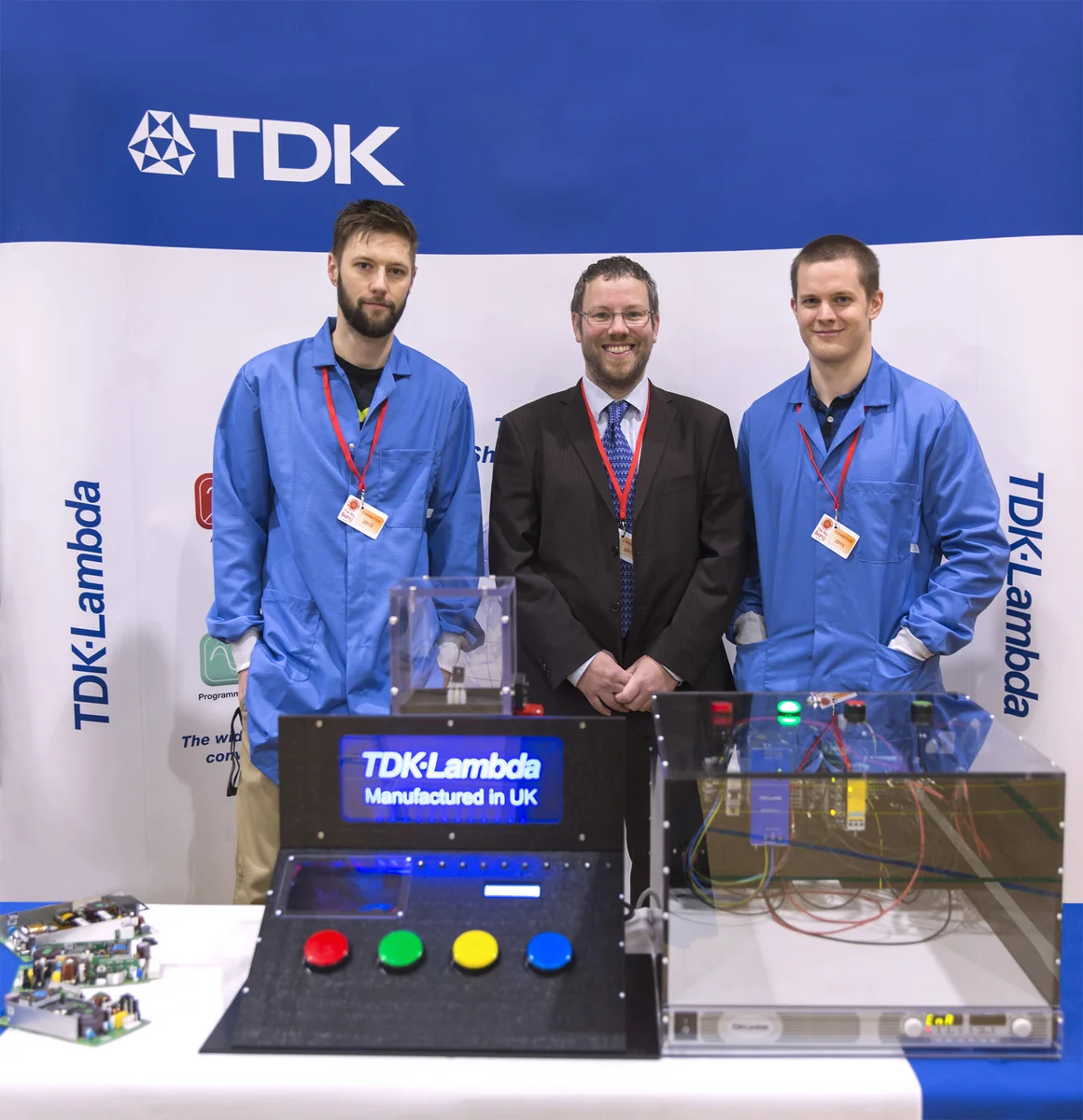 Three engineers at the TDK Lambda booth at Big Bang Fair with the Simon Says game and capacitor discharge unit